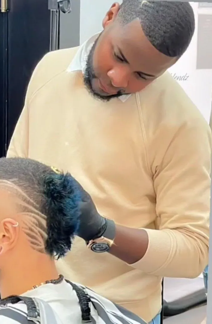 Oscar, barbero de Yovi Barbershop, haciendo un diseño a navaja en Zaragoza